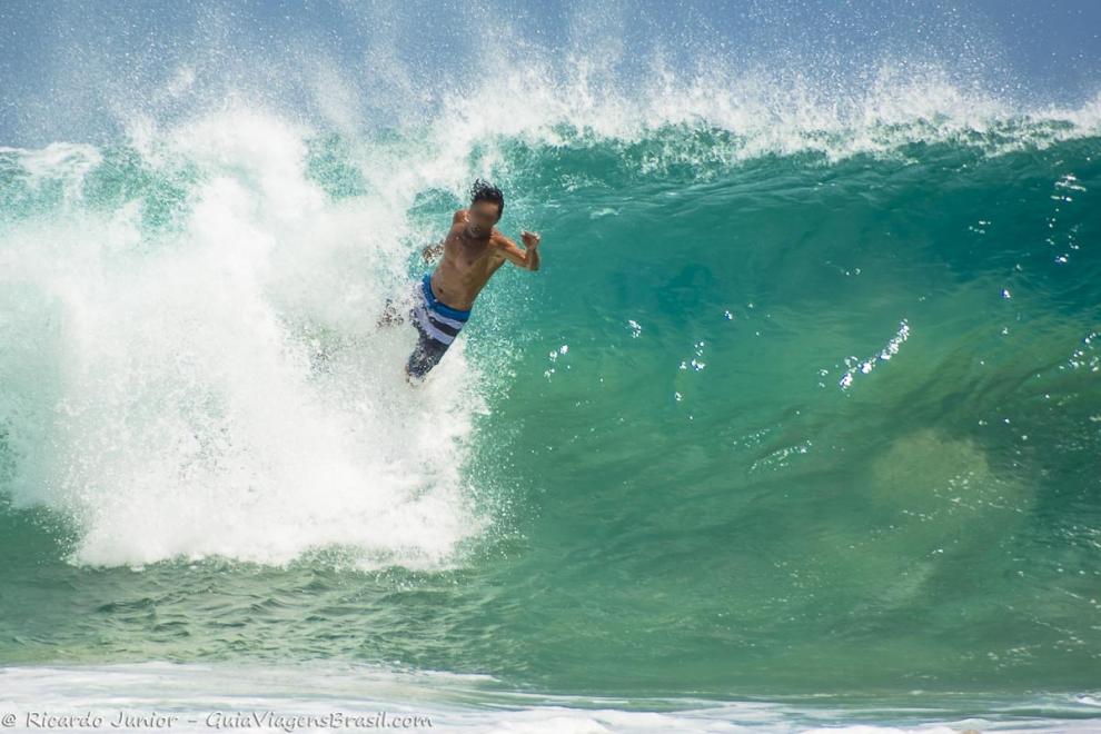 Imagem de um surfista saltando da prancha em Fernando de Noronha.